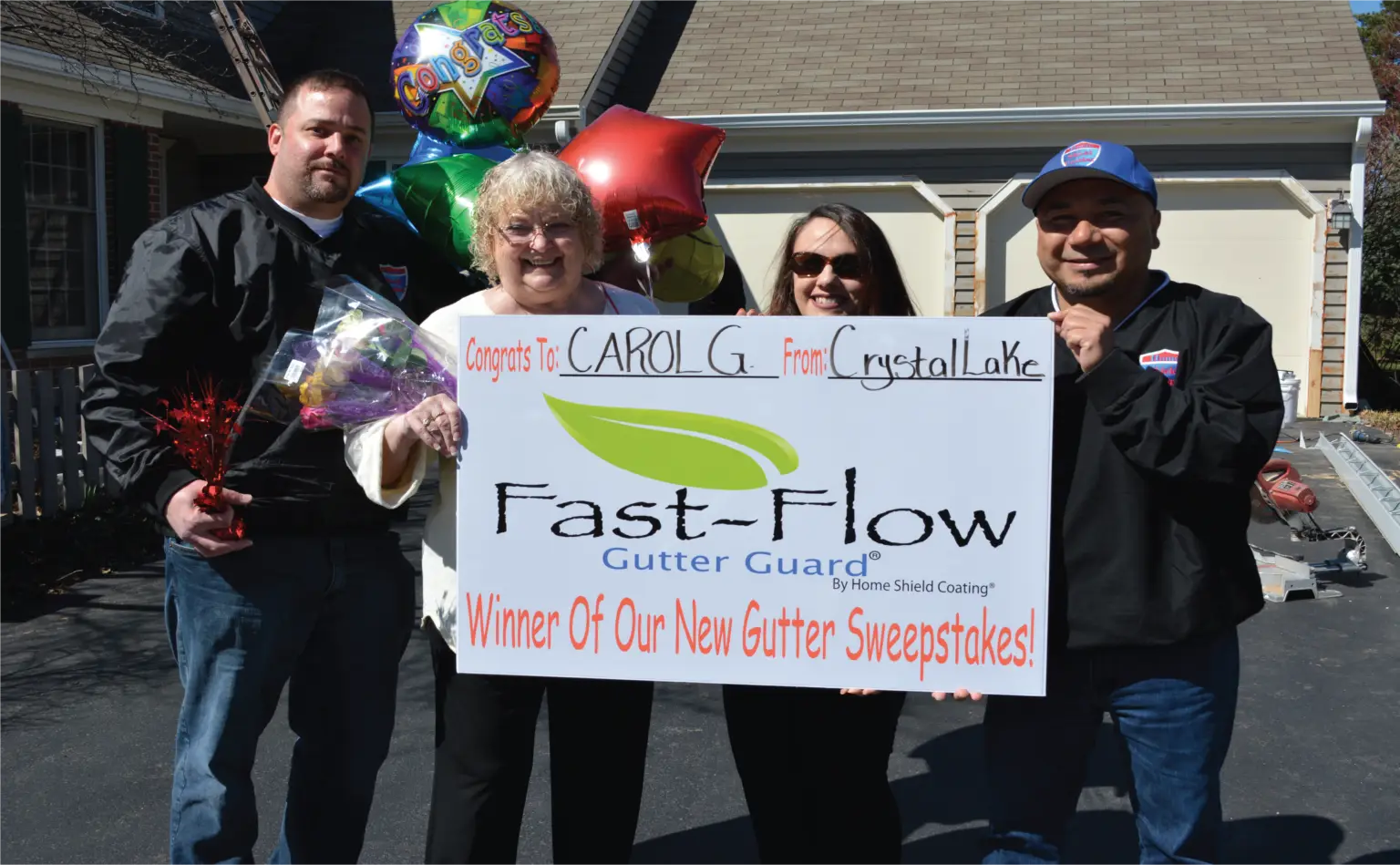 Fast-Flow Gutter Guard sweepstakes winner from Crystal Lake, IL receiving her prize from the Home Shield Coating team