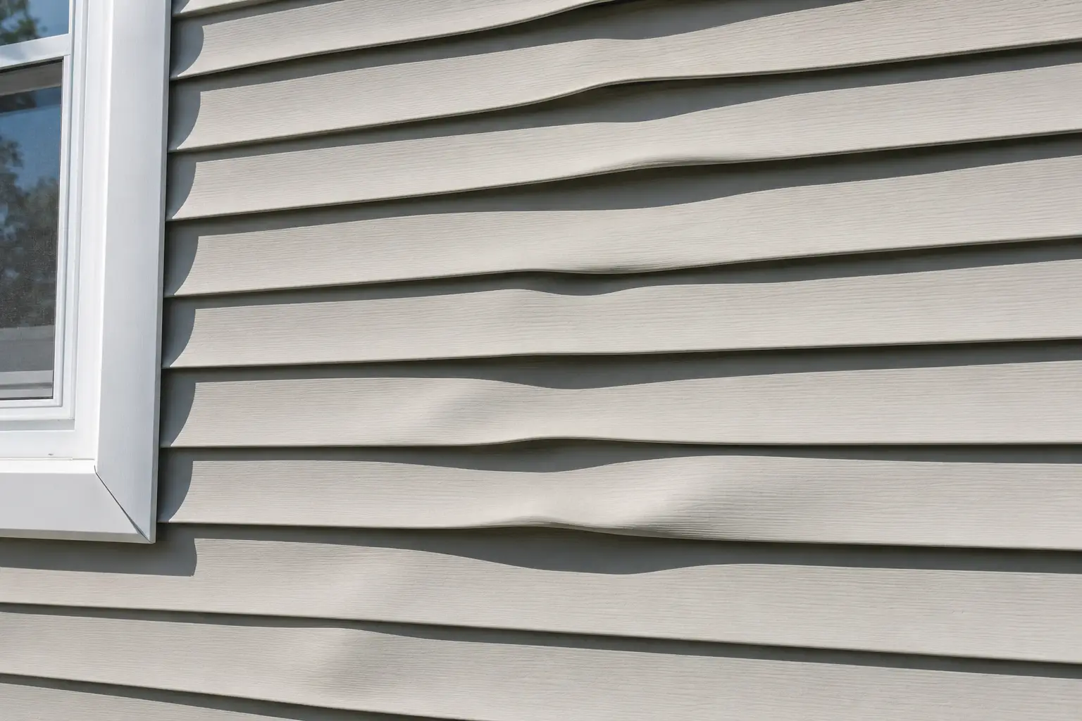 Heat-distorted vinyl siding with visible waves and buckling